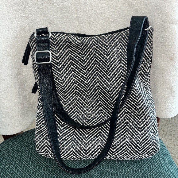 Black and white purse with two front zipper pockets. - Picture 2 of 3